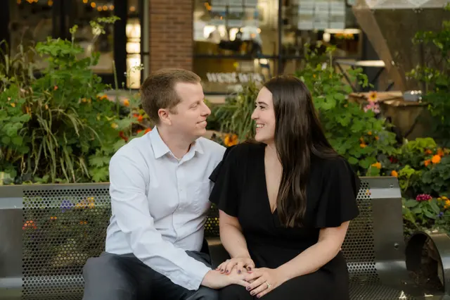 Holding hands on a downtown bench at golden hour