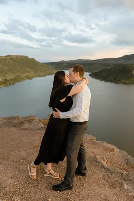 A kiss on the cliff edge with the water stretching out below