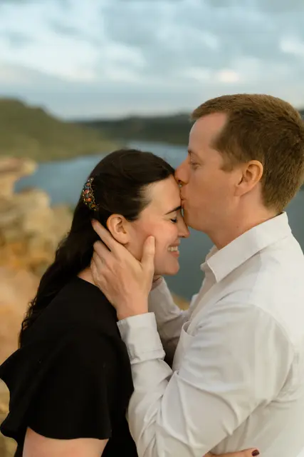 Evan kissing Brianna's forehead above the reservoir