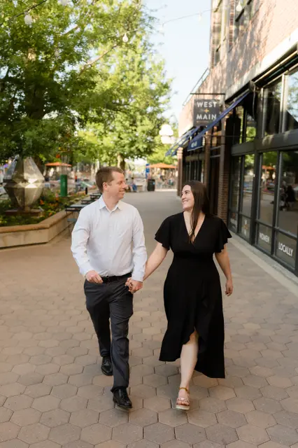 Walking hand in hand down the brick plaza past the storefronts