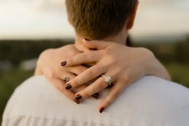 Brianna's hands clasped behind Evan's neck, her ring catching the light