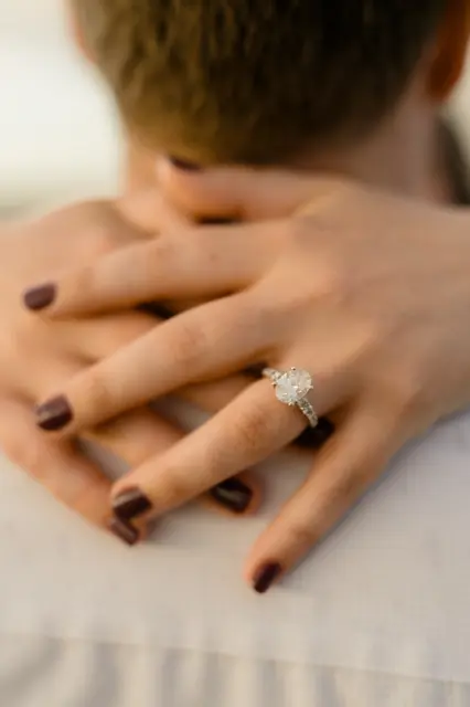 Hands and rings resting on Evan's shoulder