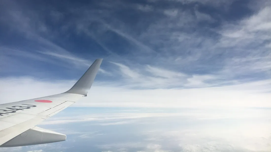 An aircraft wing above a bank of cloud