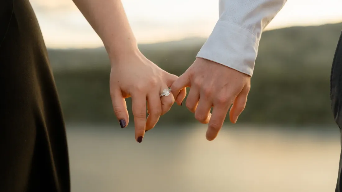 Brianna and Evan's hands linked at sunset